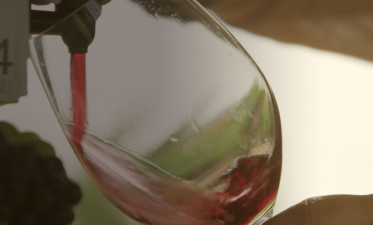 Franzia red wine pouring from the tap into a glass
